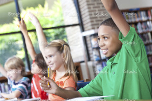 children in school raising hands