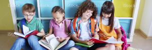 elementary school students reading while sitting on floor