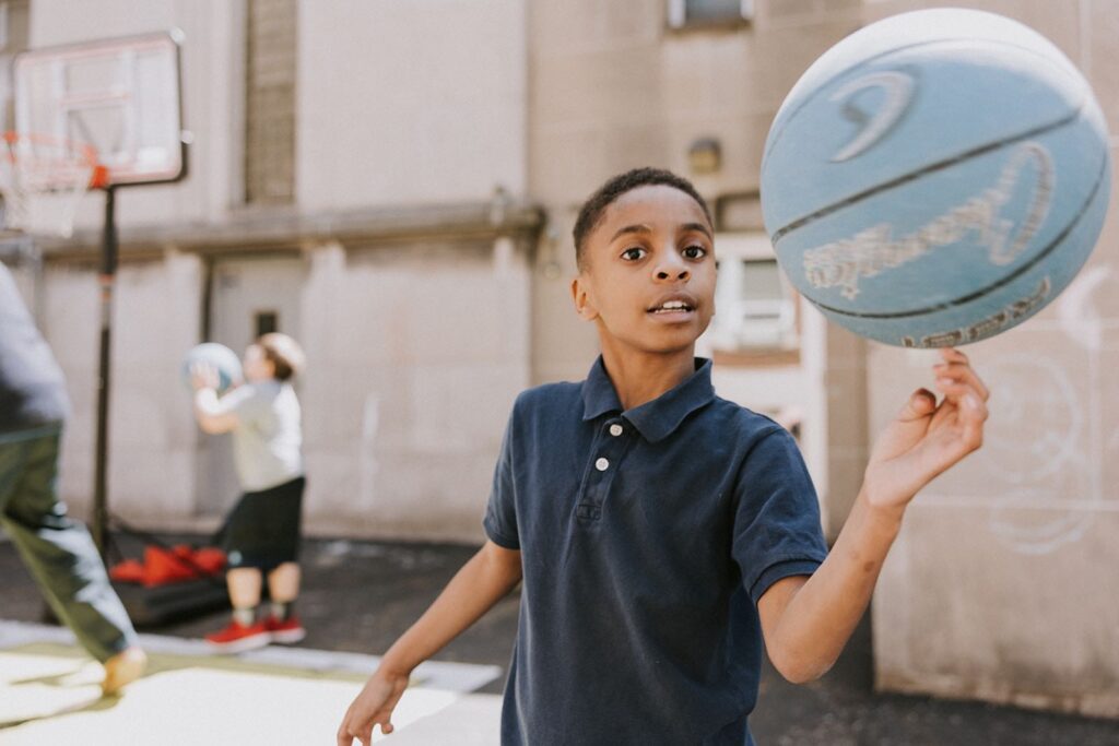 Student at Provident West charter school playing outside with a blue basketball.