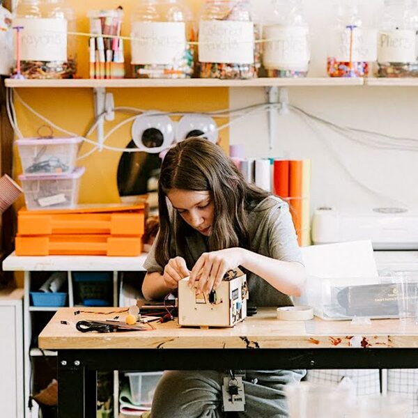 “student at Provident Charter West school working on box construction at a science room table”