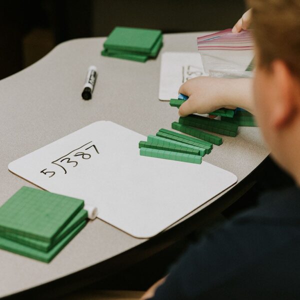 “student at Provident Charter School West tuition-free 1st-5th filling out math problem at a desk with a teacher”